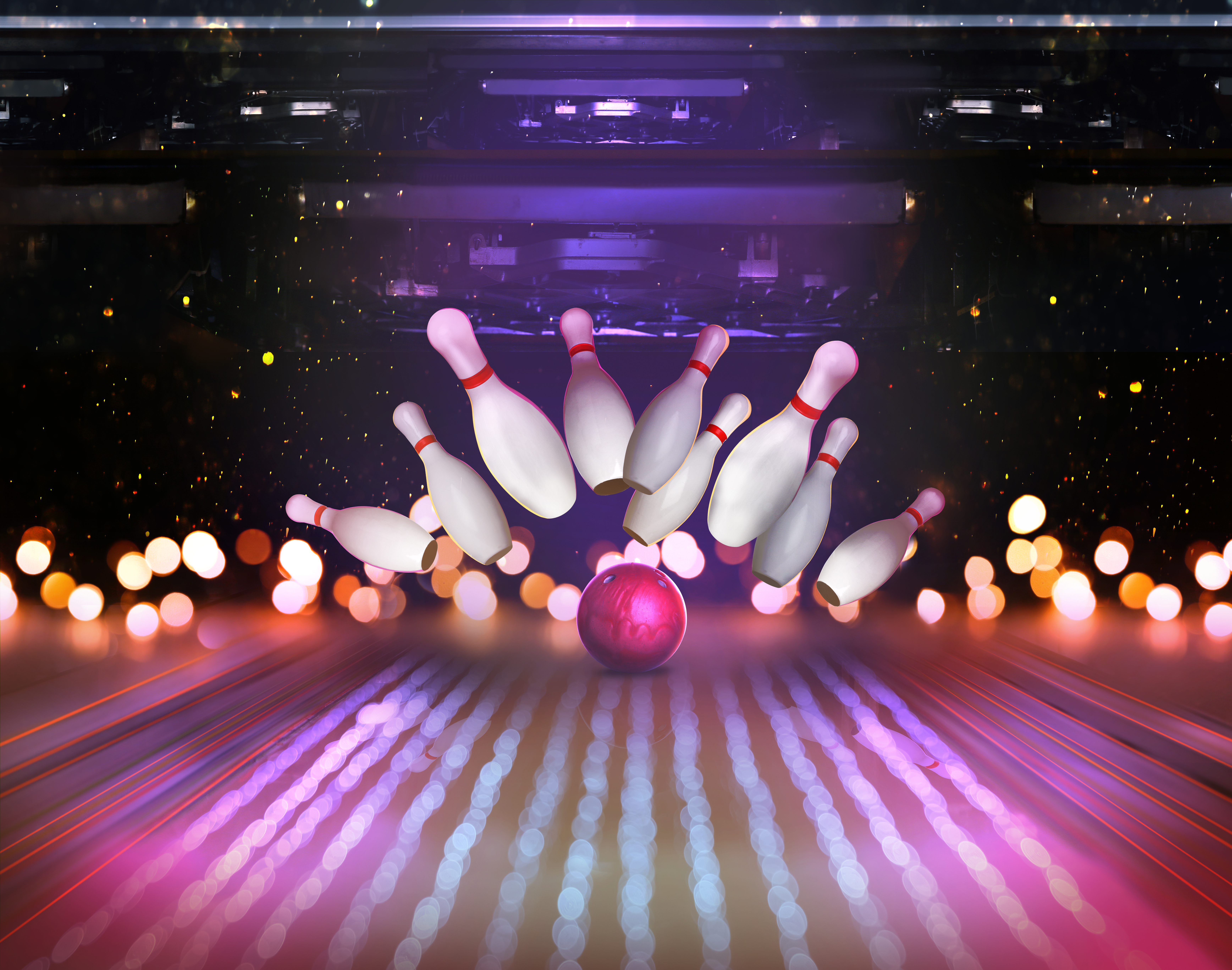 Bowlingkugel trifft die Pins auf einer bunt beleuchteten Bowlingbahn